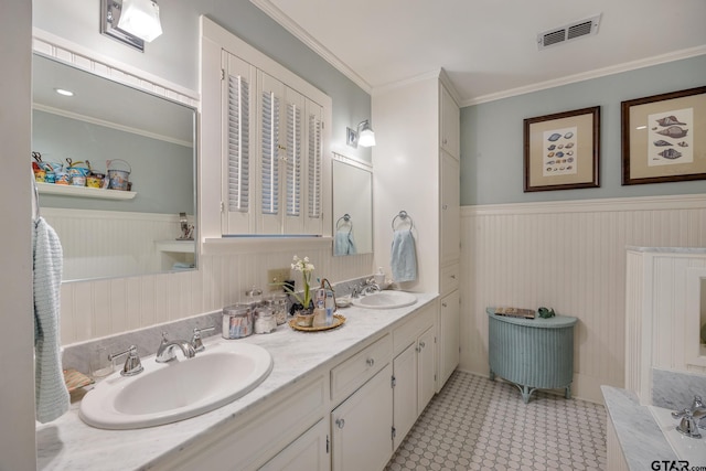 bathroom with visible vents, wainscoting, and a sink