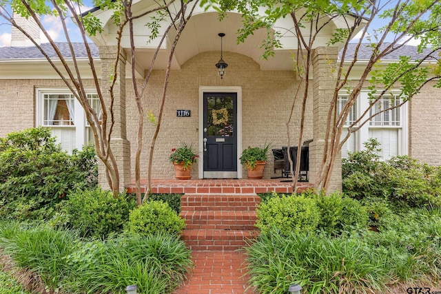 view of exterior entry featuring brick siding