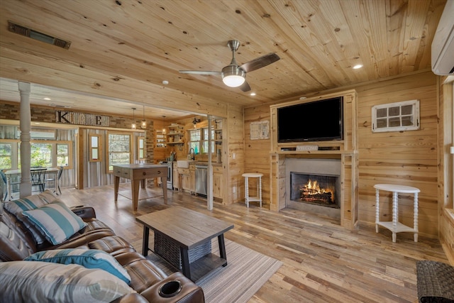 living area featuring light wood-style floors, wooden ceiling, wooden walls, and visible vents