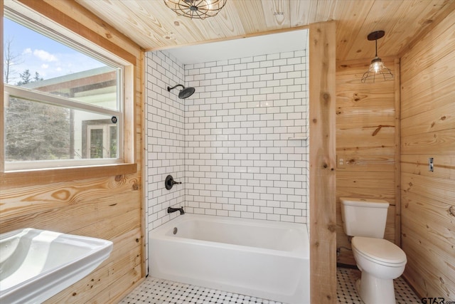 bathroom with wooden ceiling, toilet, shower / bath combination, and wood walls