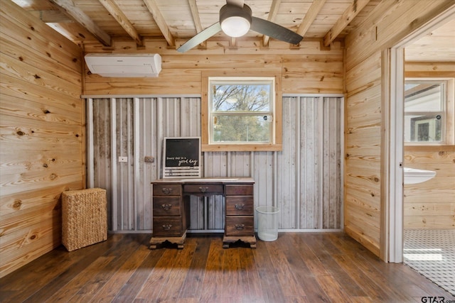 unfurnished office featuring beam ceiling, a wall mounted air conditioner, and dark wood finished floors