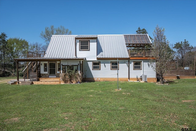 rear view of house with a lawn, stairs, central air condition unit, and metal roof