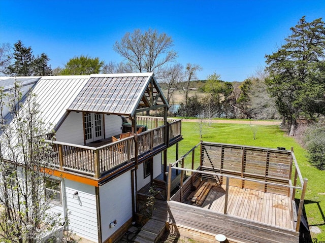 wooden deck with a lawn and french doors