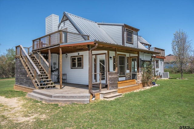 back of house with metal roof, stairs, a deck, and a yard