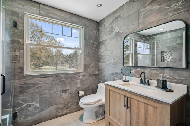 full bath featuring tile walls, vanity, toilet, and a shower stall