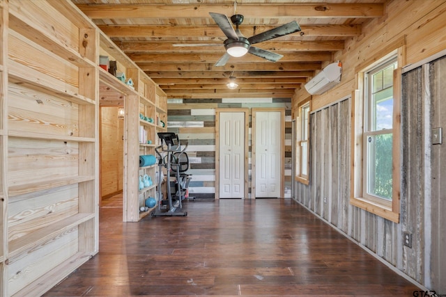 interior space featuring wood finished floors, wooden walls, an AC wall unit, and beamed ceiling