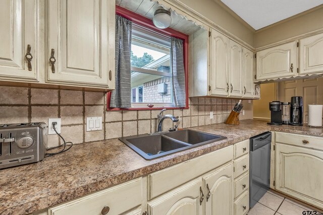 410 Shande St, Whitehouse, TX 75791 - kitchen featuring cream cabinetry, decorative backsplash, a sink, light tile patterned flooring, and dishwashing machine