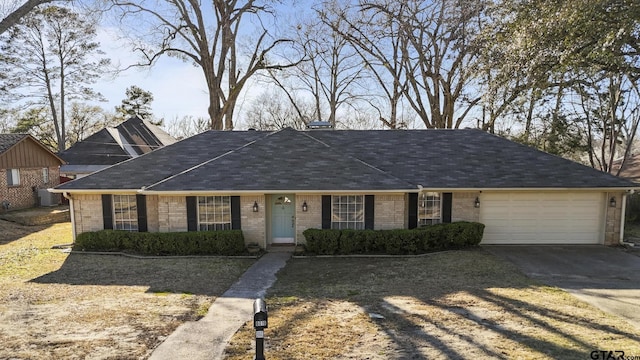 ranch-style home featuring brick siding, cooling unit, concrete driveway, and a garage