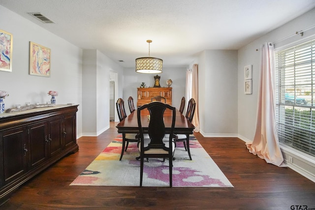 dining area featuring baseboards, visible vents, and dark wood-style flooring