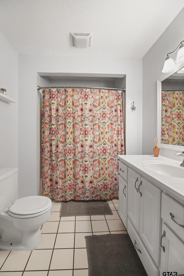 bathroom with tile patterned floors, visible vents, toilet, a textured ceiling, and vanity