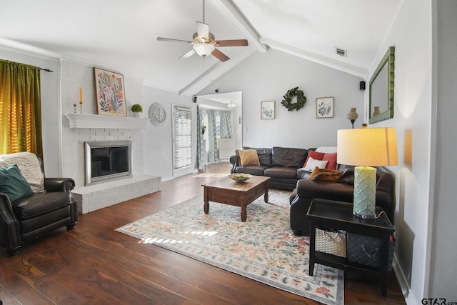 living room featuring visible vents, a brick fireplace, lofted ceiling with beams, wood finished floors, and a ceiling fan