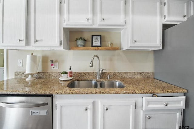 kitchen with a sink, open shelves, light stone countertops, and white cabinets