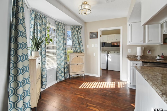 kitchen featuring dark stone countertops, dark wood-style floors, separate washer and dryer, white cabinets, and baseboards