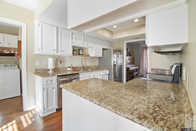 kitchen featuring dark wood finished floors, a peninsula, stainless steel appliances, washer / clothes dryer, and a sink