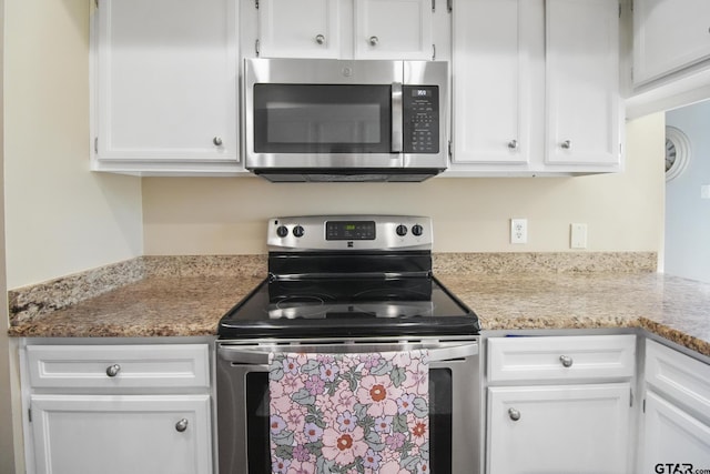 kitchen with light stone counters, stainless steel appliances, and white cabinets