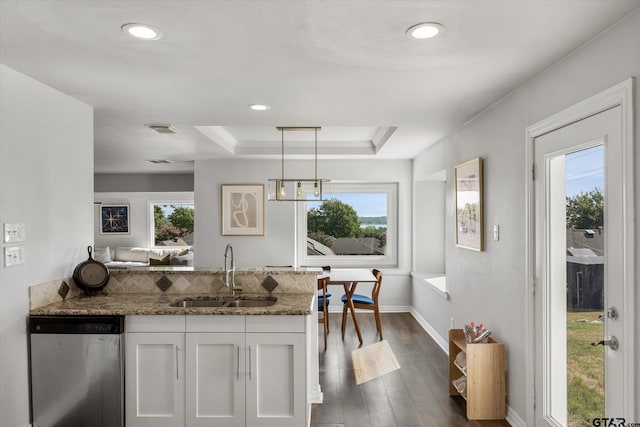 kitchen with stone counters, hanging light fixtures, sink, stainless steel dishwasher, and white cabinetry