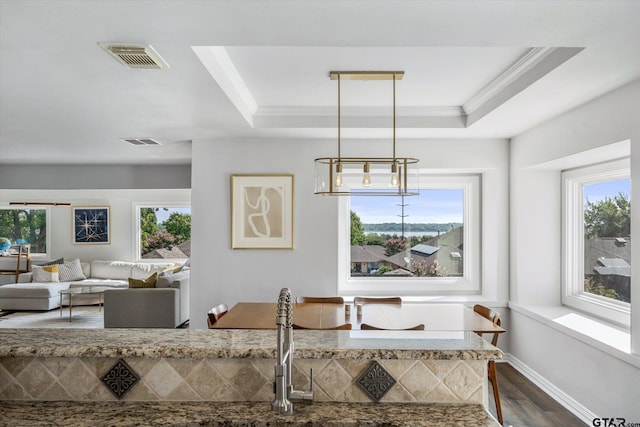 dining area with dark hardwood / wood-style floors, crown molding, and a tray ceiling