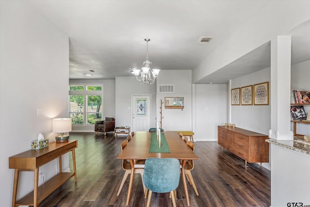 dining area featuring an inviting chandelier and dark wood-type flooring