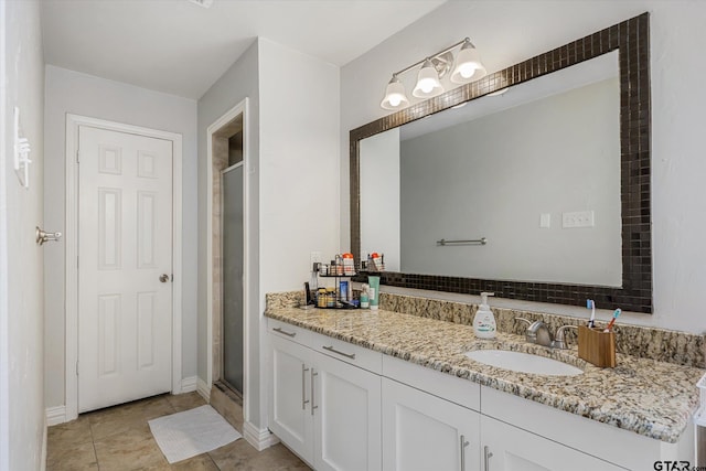 bathroom featuring tile patterned flooring, vanity, and a shower with shower door