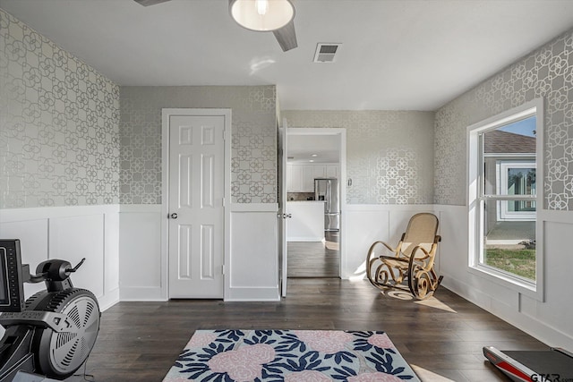 sitting room with ceiling fan and dark wood-type flooring