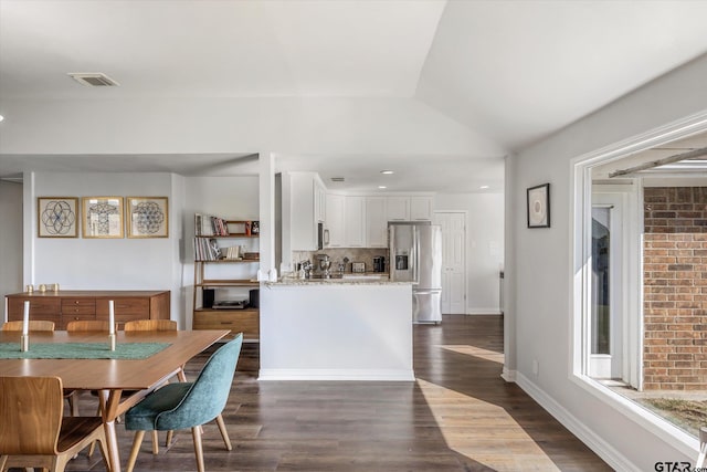 dining space with dark hardwood / wood-style flooring and vaulted ceiling