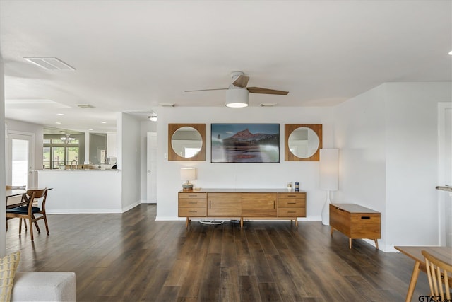 living room featuring ceiling fan and dark wood-type flooring