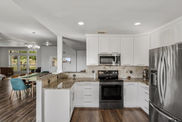 kitchen with kitchen peninsula, dark hardwood / wood-style flooring, stainless steel appliances, stone countertops, and white cabinets