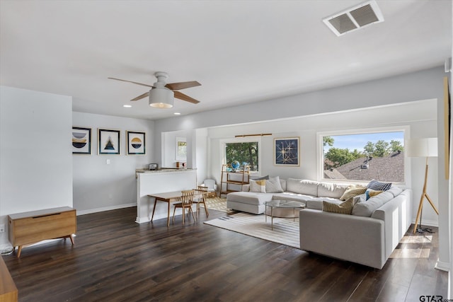 living room featuring ceiling fan and dark hardwood / wood-style flooring