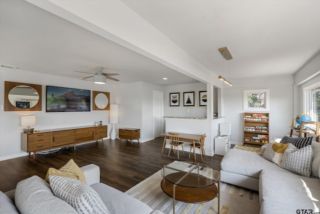 living room featuring ceiling fan and dark wood-type flooring