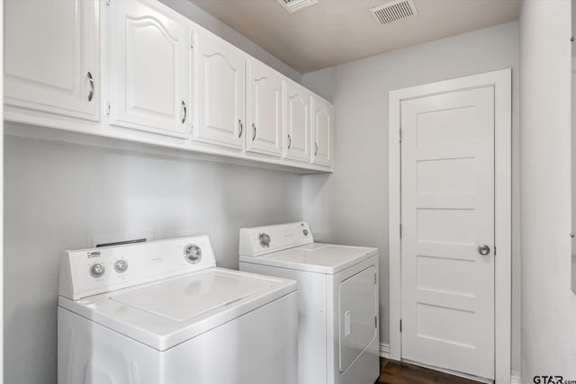 laundry room featuring cabinets, dark hardwood / wood-style floors, and independent washer and dryer