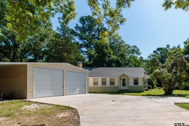 view of front of house with a garage, a front lawn, and an outdoor structure