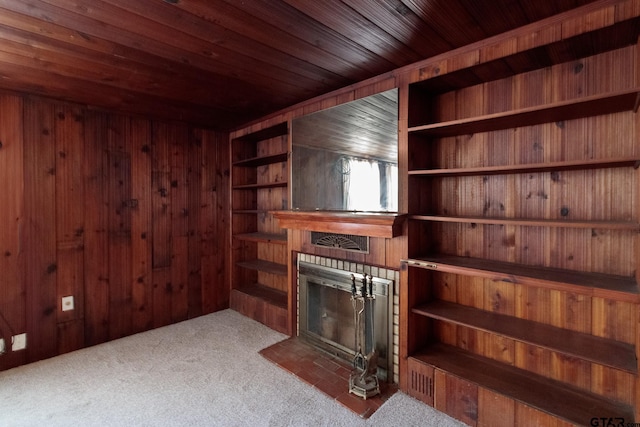 carpeted living room featuring wooden walls, a fireplace, and wooden ceiling