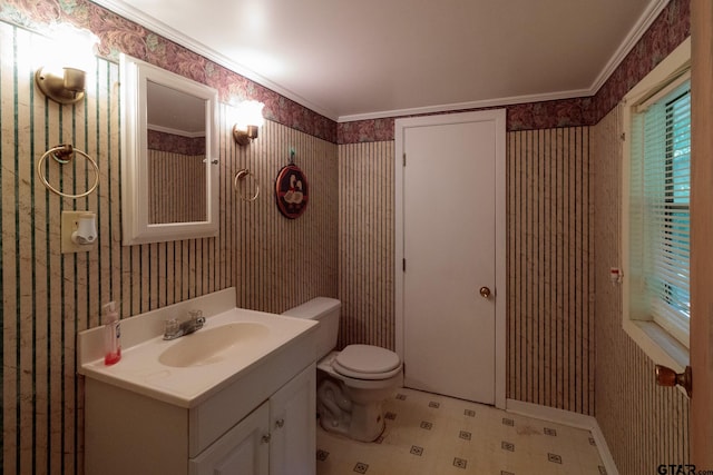 bathroom with toilet, vanity, and ornamental molding