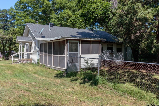 view of front of house featuring a sunroom and a front yard