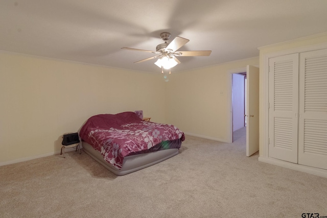 carpeted bedroom featuring ceiling fan and ornamental molding