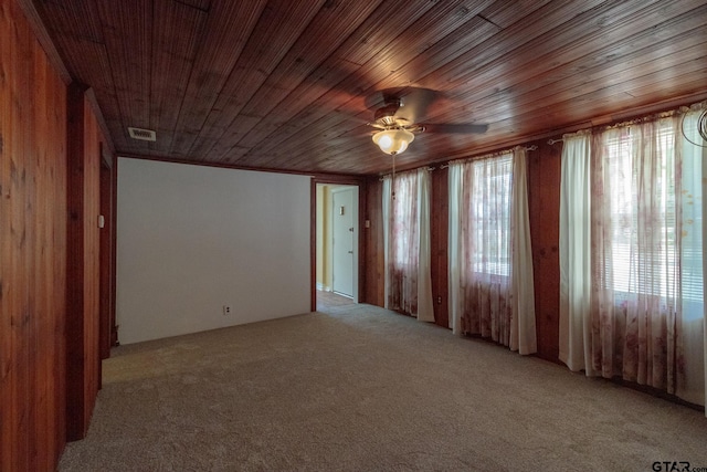 spare room featuring ceiling fan, a healthy amount of sunlight, wooden ceiling, and light carpet