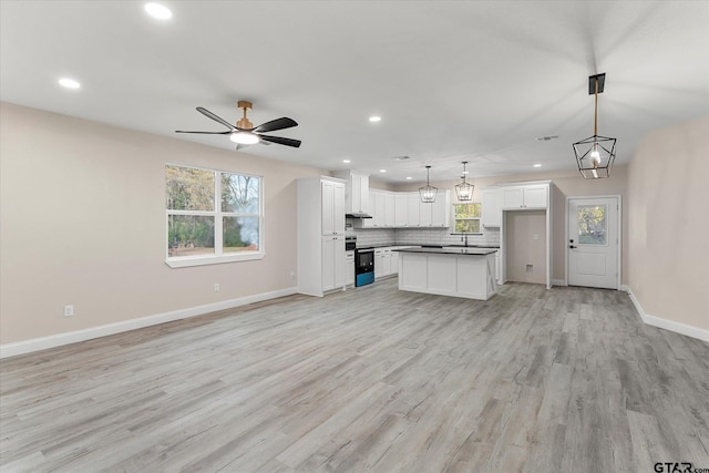 unfurnished living room featuring light wood-type flooring and ceiling fan