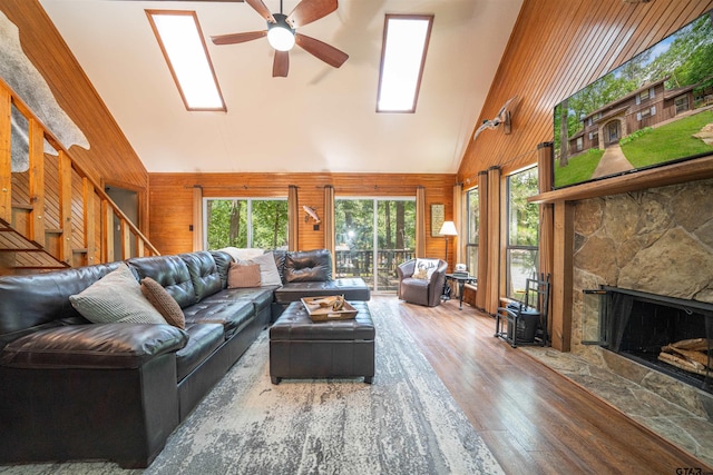203 King Laurence Ct, Scroggins, TX 75480 - living room featuring wooden walls, high vaulted ceiling, wood finished floors, ceiling fan, and a fireplace