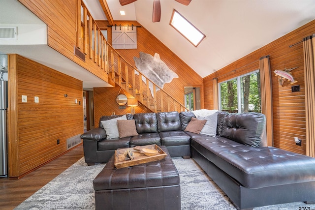 203 King Laurence Ct, Scroggins, TX 75480 - living area featuring wood walls, ceiling fan, wood finished floors, stairway, and high vaulted ceiling