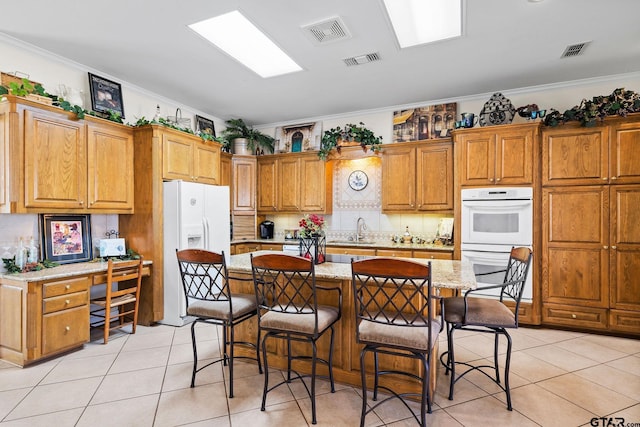 kitchen featuring visible vents, white appliances, and crown molding