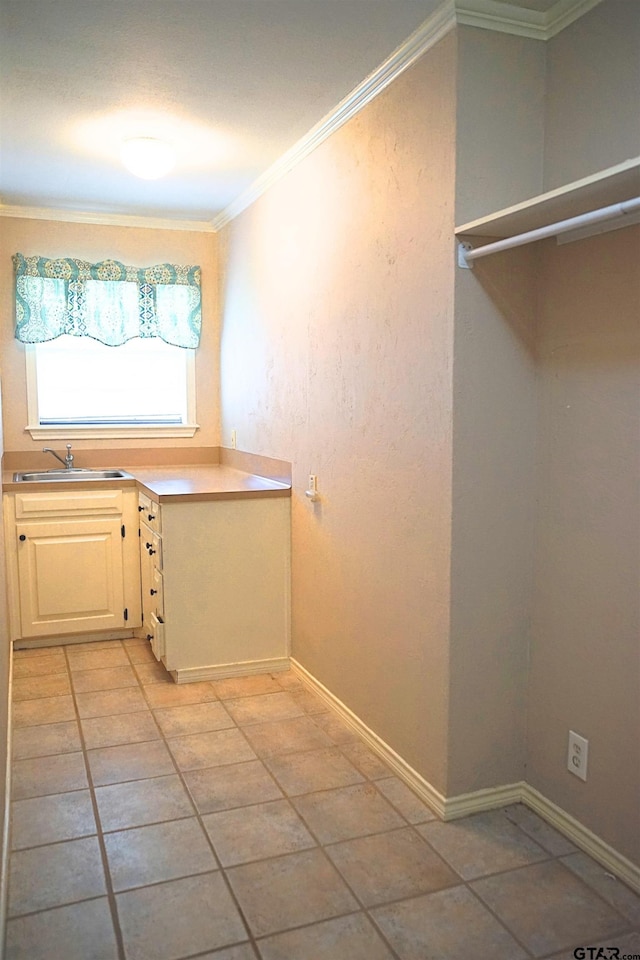 washroom featuring sink, ornamental molding, and light tile patterned flooring