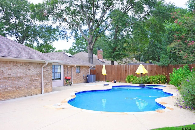 view of swimming pool featuring central AC unit, an in ground hot tub, and a patio