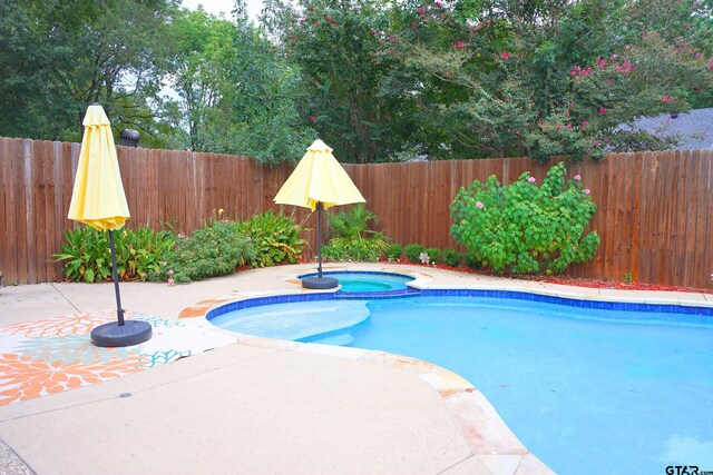 view of pool featuring a patio area and an in ground hot tub