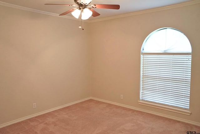 empty room with ceiling fan, light colored carpet, and crown molding