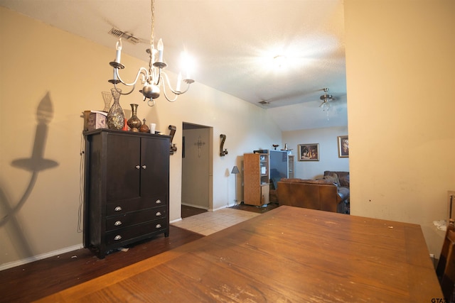 dining area featuring vaulted ceiling, ceiling fan with notable chandelier, a textured ceiling, and wood-type flooring