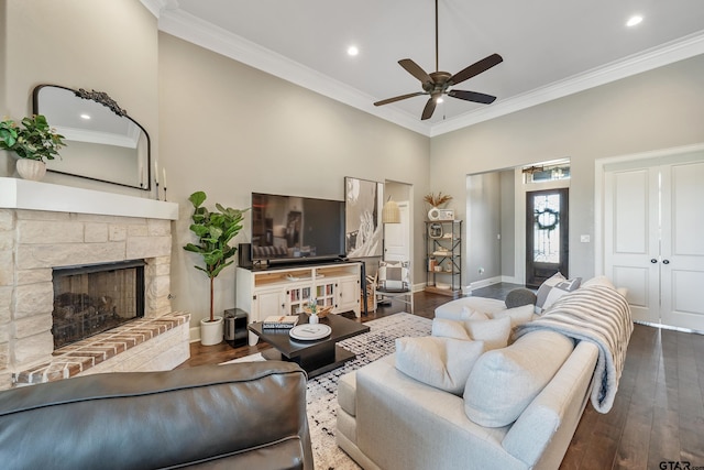 2921 Guinn Farms Rd, Tyler, TX 75707 - living area featuring dark wood-style floors, ornamental molding, a ceiling fan, a stone fireplace, and baseboards