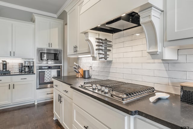 2921 Guinn Farms Rd, Tyler, TX 75707 - kitchen featuring stainless steel appliances, white cabinets, ornamental molding, backsplash, and dark wood-type flooring