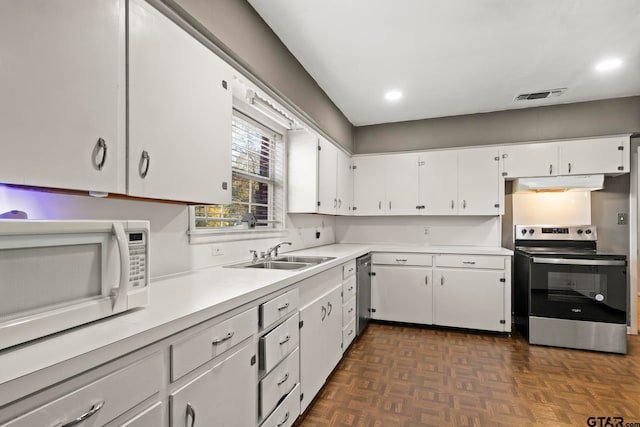 kitchen featuring white cabinetry, appliances with stainless steel finishes, sink, and dark parquet flooring