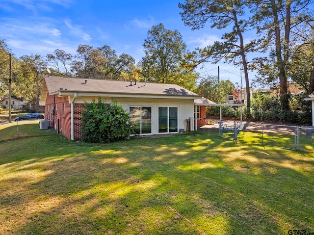 back of property featuring a lawn and cooling unit