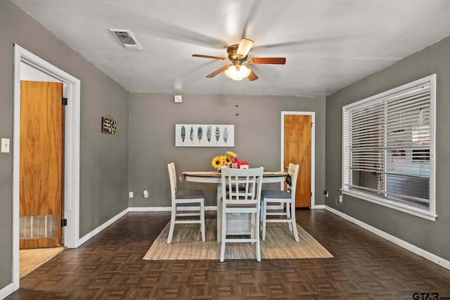 dining room featuring dark parquet floors and ceiling fan